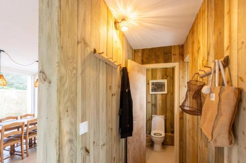 La salle de bains est pourvue de toilettes et d'un mur en bois. dans l'établissement Ker bohème, à Noyal-Muzillac