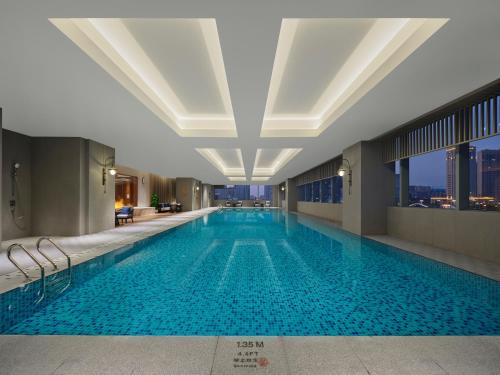 a swimming pool in a hotel with a view of the city at Doubletree By Hilton Rugao in Rugao