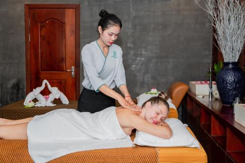 a woman getting a massage from a massage therapist at Bayon Modern Residence in Siem Reap