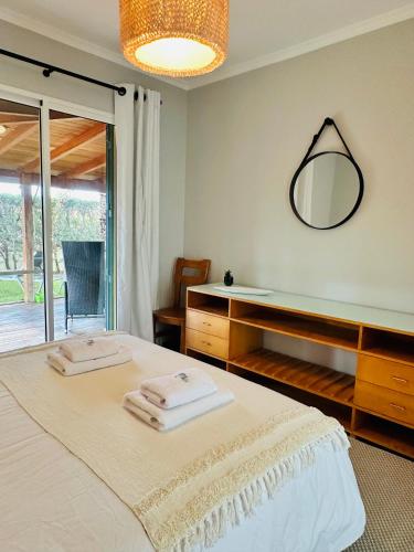 a bedroom with a bed with a mirror on the wall at Quinta do Ribeiro Salgado's Beach House in Porto Santo