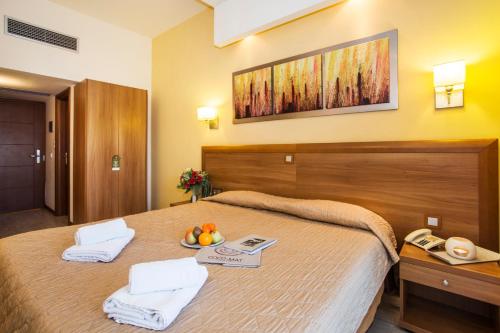 a hotel room with a bed with a bowl of fruit on it at Pefka Hotel in Thessaloniki