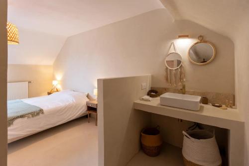 une chambre avec un lit, un lavabo et un miroir dans l'établissement Ker bohème, à Noyal-Muzillac