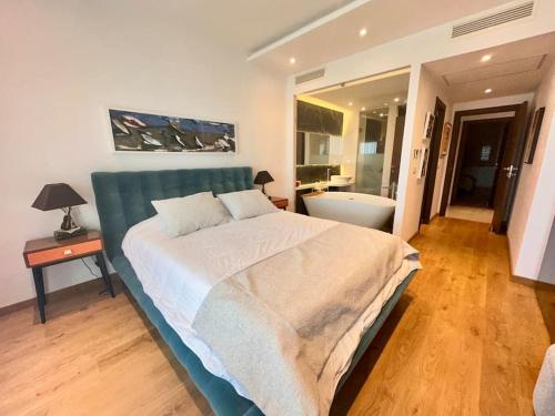 a bedroom with a large bed and a bathroom at Les Jasmins Gammarth, luxueux appartement pour 4 in La Marsa