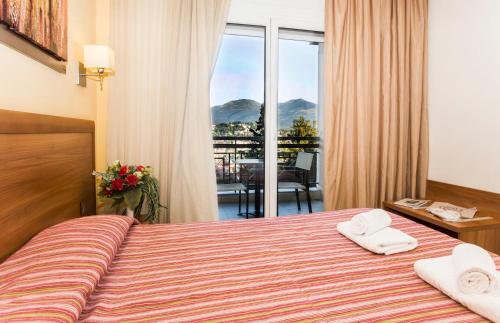 a hotel room with a bed with two towels on it at Pefka Hotel in Thessaloniki