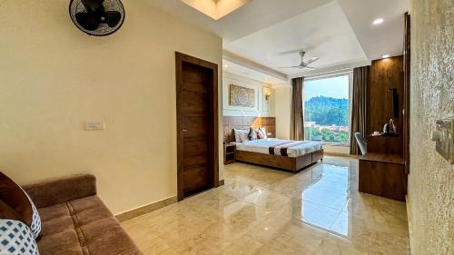 Un dormitorio con una cama y una ventana grande. en Hotel Nirvana Bliss, Behind Parmarth Niketan, en Rishīkesh