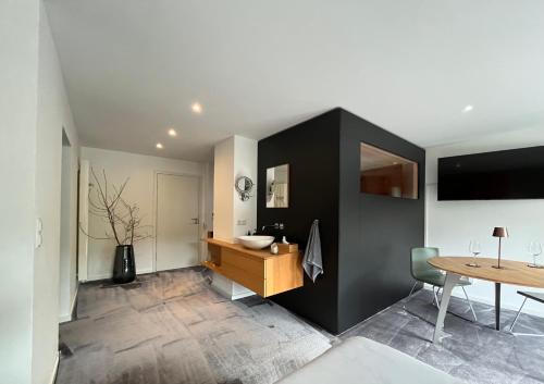 a bathroom with a sink and a wooden table at Bonne âme - Ferienwohnung mit Sauna in Sankt Martin