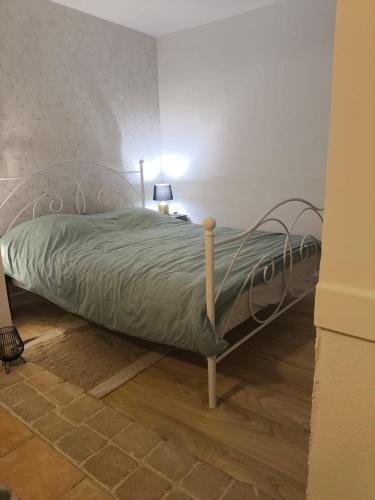 a bed in a bedroom with a green comforter at Charmant Studio in Marseille