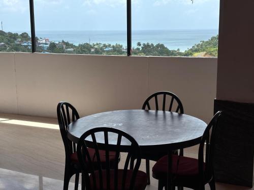 a table and chairs in a room with a window at The Tamarind Tree Hotel & Restaurant in Shādipur
