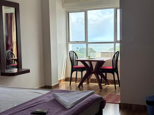 a bedroom with a table and chairs and a window at The Tamarind Tree Hotel & Restaurant in Shādipur