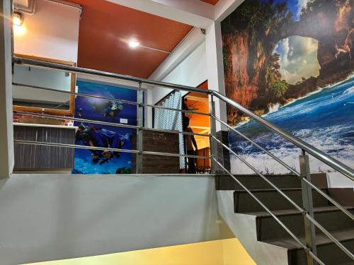 a staircase in a building with a mural on the wall at The Tamarind Tree Hotel & Restaurant in Shādipur