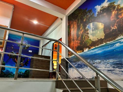 a mural on the wall of a building with a staircase at The Tamarind Tree Hotel & Restaurant in Shādipur