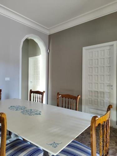 a dining room table with chairs and a white table at Villa Carmela in Martina Franca