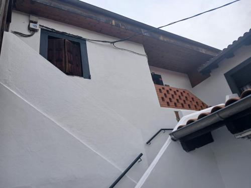 a window on the side of a white building at La casa del patio in La Arboleda