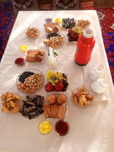 een tafel met veel verschillende soorten voedsel erop bij Koshoi Ata guest house in Kalday