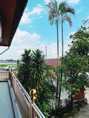 a balcony with palm trees and a white fence at Venn Hostel in Vientiane