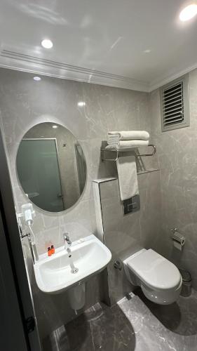 a bathroom with a sink and a toilet and a mirror at Espoir HOTEL in Istanbul