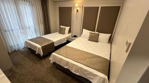 a hotel room with two beds and a mirror at Espoir HOTEL in Istanbul