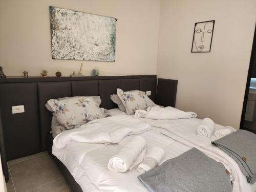 Una cama con sábanas blancas y toallas. en Apartament Tirana Contact, en Tirana
