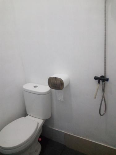 a bathroom with a toilet and a roll of toilet paper at Surya homestay in Batukaras