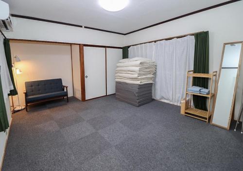 a living room with a chair and a stack of towels at GLOCE 南伊豆アウトドアベースキャンプ（ゲストハウス） in Minamiizu