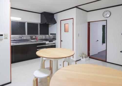 a kitchen with a table and stools in a room at GLOCE 南伊豆アウトドアベースキャンプ（ゲストハウス） in Minamiizu