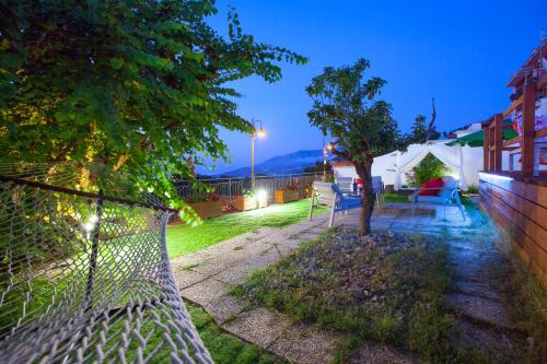 a backyard with a fence and a tree at night at Appartamento in Villa con Terrazzo e Vista Golfo in Massa Lubrense