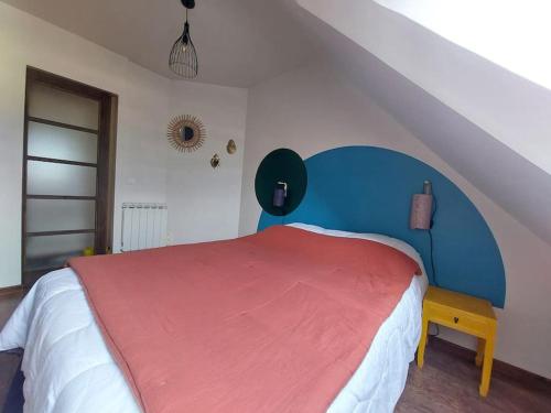 a bedroom with a bed with a red and blue headboard at Confort entre lac et montagne in Tresserves