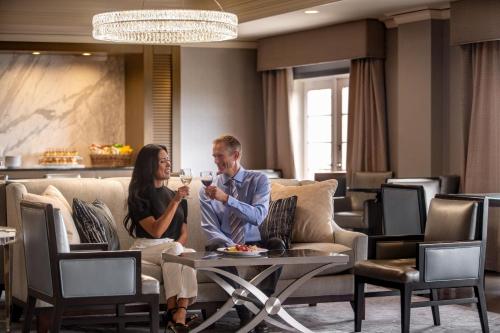 a man and woman sitting on couches in a hotel lobby at The Ritz-Carlton, St. Louis in Clayton