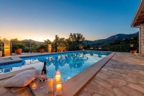 a swimming pool with a table and a bottle of wine at Villa Paulina in Mlini