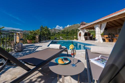 a villa with a pool and a table with a bowl of fruit at Villa Paulina in Mlini
