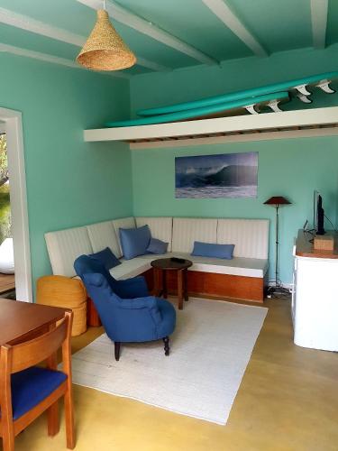 a room with a bed and a couch and a table at Conde Surf Camp - Capsule Beds FEMALE Dorm in Vila do Conde