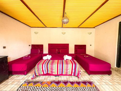 two beds in a room with red beds sidx sidx sidx at Tonaroz House in Imlil