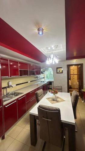 a kitchen with red cabinets and a table with chairs at Bella space in Suceava