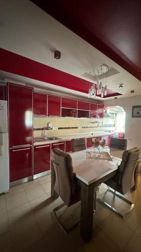 a kitchen with red cabinets and a table and chairs at Bella space in Suceava