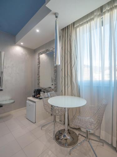 a dining room with a table and chairs and a mirror at San Valentino Hotel in Villa di Serio