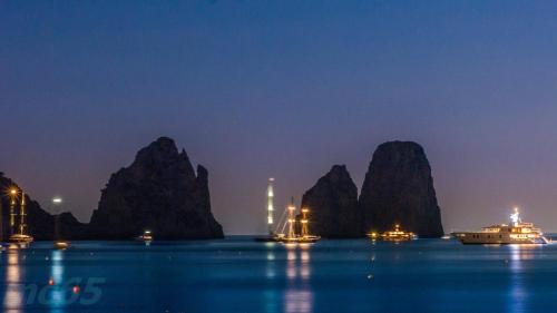 a group of boats in the water at night at Hotel Weber Ambassador in Capri