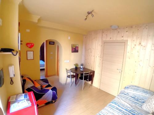 a living room with a table and a bedroom at Le Perle di Alessia in Stazione La Spezia Migliarina