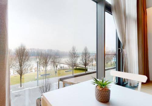 a room with a large window with a white table at Eurovea Apartments in Bratislava