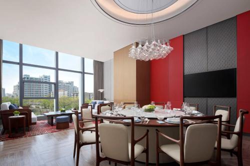 a dining room with a table and chairs and a chandelier at Yancheng Marriott Hotel in Yancheng