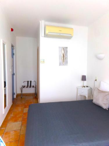 a bedroom with a bed with a blue bedspread at Hotel Du Lac in Château-Arnoux-Saint-Auban