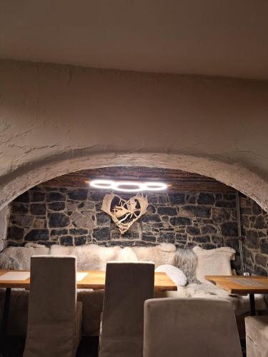 a dining room with a stone fireplace with a table and chairs at Miss cocotte champêtre in Gesves