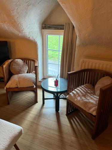 a room with two chairs and a table and a window at Miss cocotte champêtre in Gesves