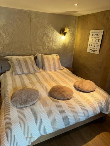 a bed with two pillows on top of it at Miss cocotte champêtre in Gesves