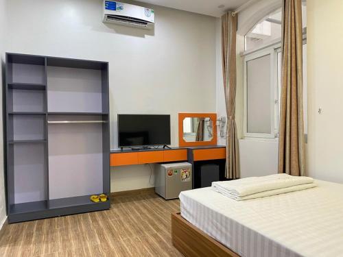 a bedroom with a bed and a desk with a television at Holiday Hotel 2 in Hai Phong