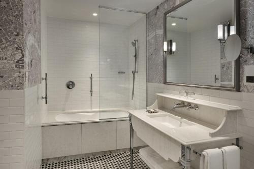 a white bathroom with a sink and a shower at London Marriott Hotel County Hall in London