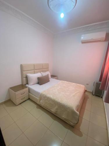 a bedroom with a bed and a light on the ceiling at Marwan's apartment 2 in Ifrane
