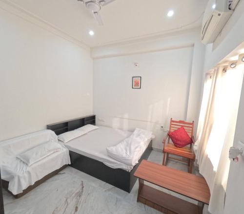 a bedroom with two beds and a chair at CHOUDHARY WHITE HOUSE Udaipur in Udaipur