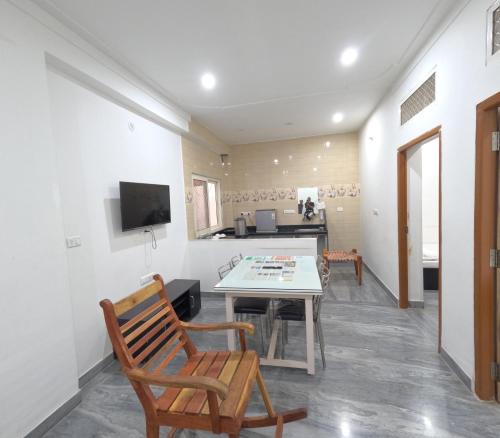 a living room with a table and chairs and a television at CHOUDHARY WHITE HOUSE Udaipur in Udaipur