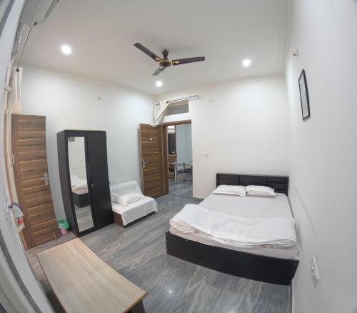 a room with two beds and a mirror in it at CHOUDHARY WHITE HOUSE Udaipur in Udaipur