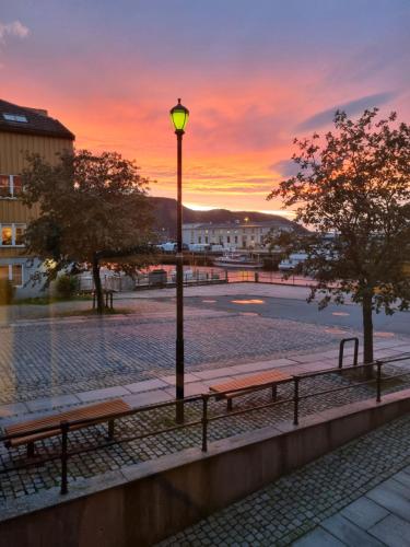 a street light and benches with a sunset in the background at Brygga B&B Trondheim sentrum, privat rom i vårt hjem in Trondheim